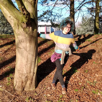 Sol standing near a tree